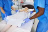 Two caregivers repositioning patient with Cardinal Health underpad