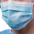 Clinician wearing a pleated blue Cardinal Health ASTM Level 3 surgical mask