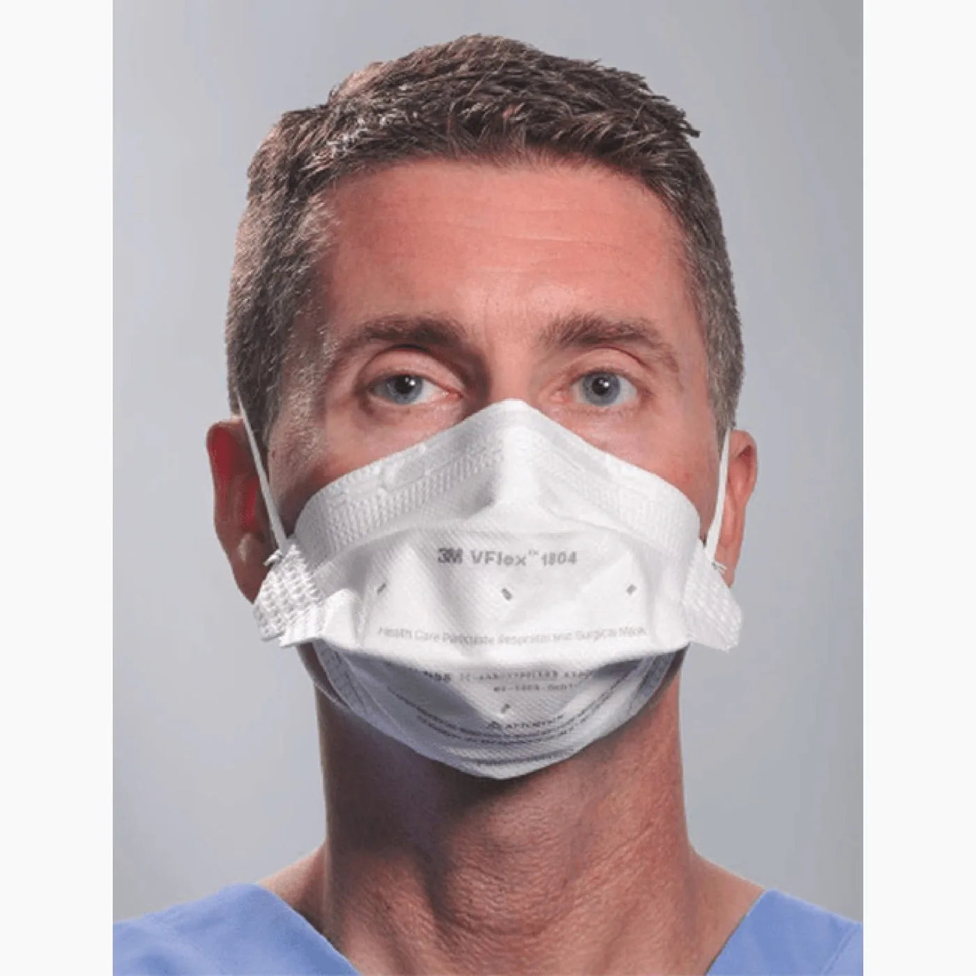 Healthcare worker in scrubs wearing the 3M VFlex 1804 surgical N95 respirator