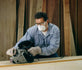 Woodworker wearing the 3M 8210 N95 respirator while belt sanding a board