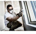 Worker wearing the 3M 8200 N95 respirator and safety glasses while sanding drywall