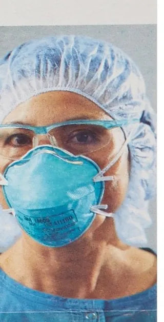 Clinician in a surgical cap and eyewear wearing the 3M 1860 N95 respirator
