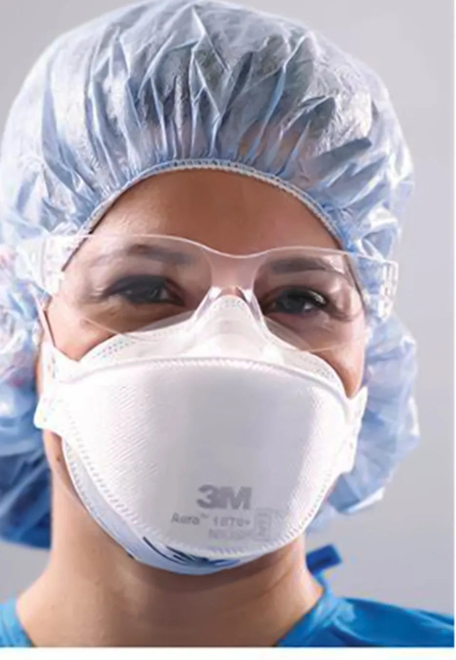 Health care worker in surgical cap and safety glasses wearing the 3M Aura 1870+ N95 surgical respirator