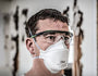 Person wearing the 3M Aura 9205 Plus N95 respirator with safety glasses