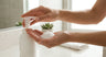 Woman applying Guardelle foaming hand sanitizer showing soft foam in palm