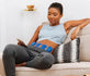 Woman using PowerDot 2.0 Duo on abdomen for pain relief at home